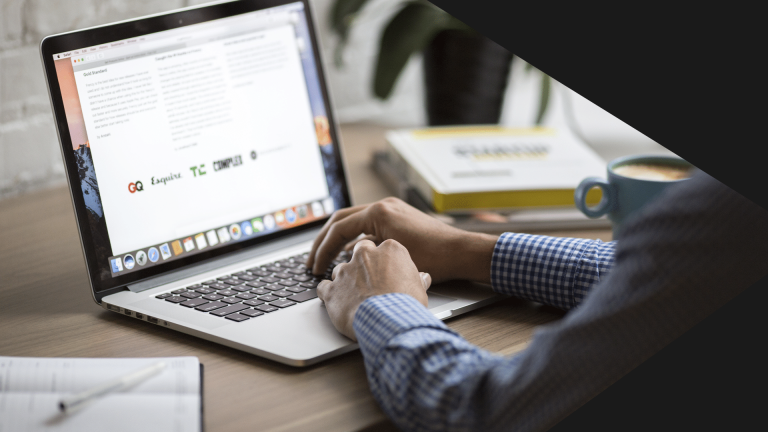 Na fotografia estão os braços de um homem, que está utilizando um notebook