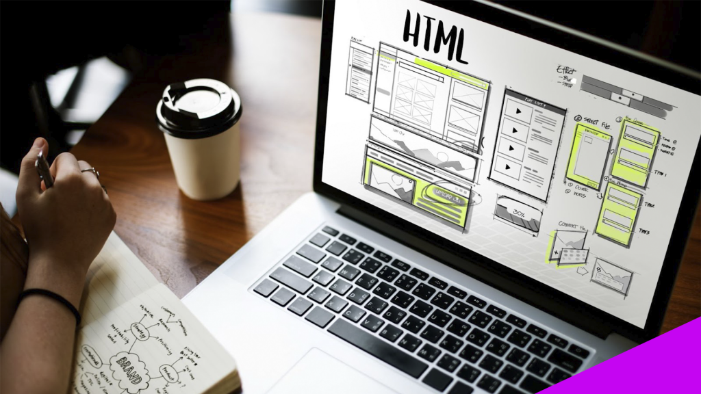 Pessoa com um computador e um caderno, ambos com desenhos de layouts e designs, para representar a estruturação de um site.