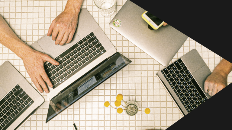 Na imagem, a mão de uma pessoa branca repousa sobre o notebook enquanto acessa a internet.