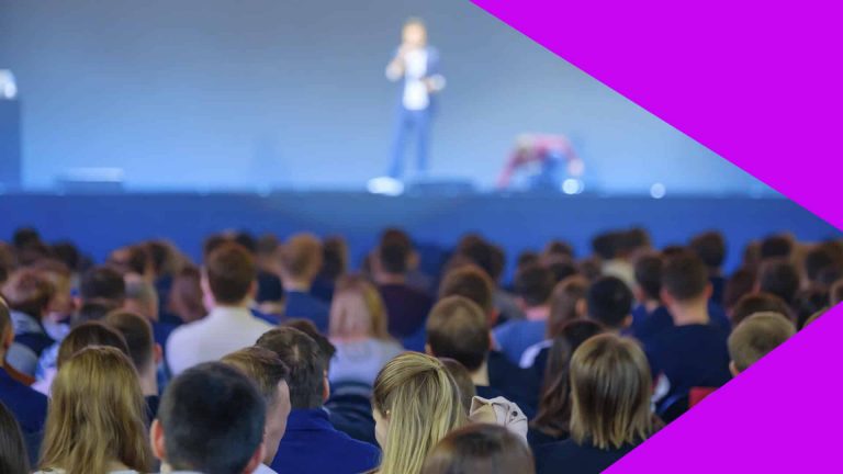 Diversas pessoas sentadas , assistindo uma palestra, durante um evento chama NRF.