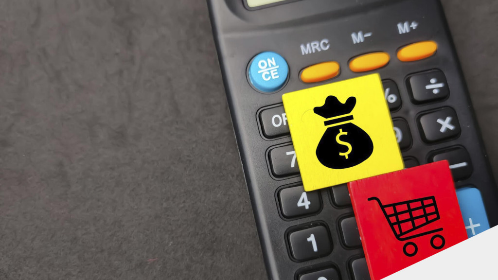 Calculadora em cima de uma mesa, com um botão amarelo com um símbolo de dinheiro, e outro vermelho com um carrinho de compras.