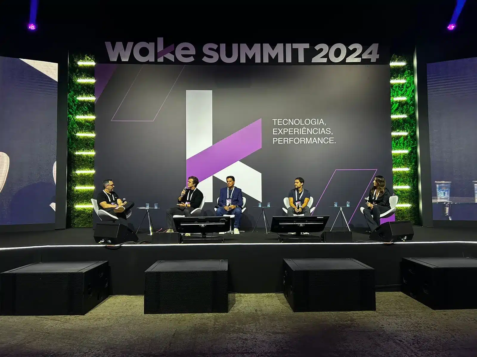 Palestra que aconteceu no Wake Summit, dia 19 de setembro com 4 pessoas debatendo os temas de unified commerce e omnichannel no palco principal do evento, sentados em cadeiras.